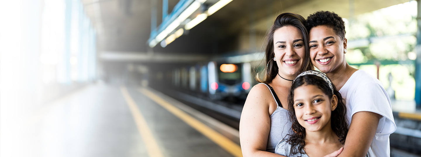 a couple-two women and girl stranding on subway train platform smiling